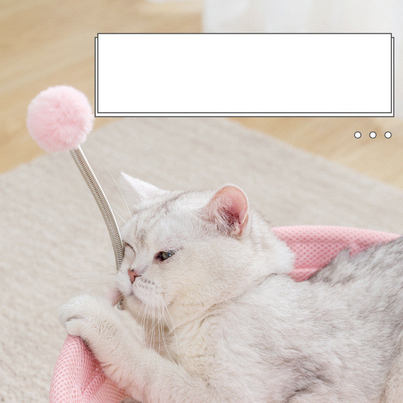 Cat playing with a pink toy on a soft surface