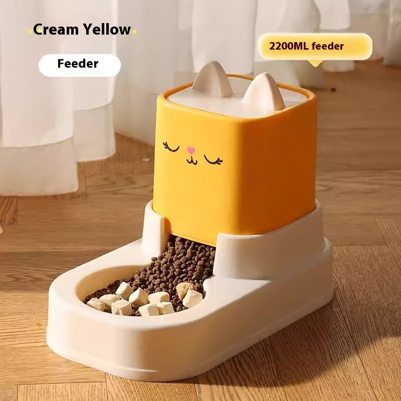 Pet feeder with cream yellow top and white base on a wooden floor.