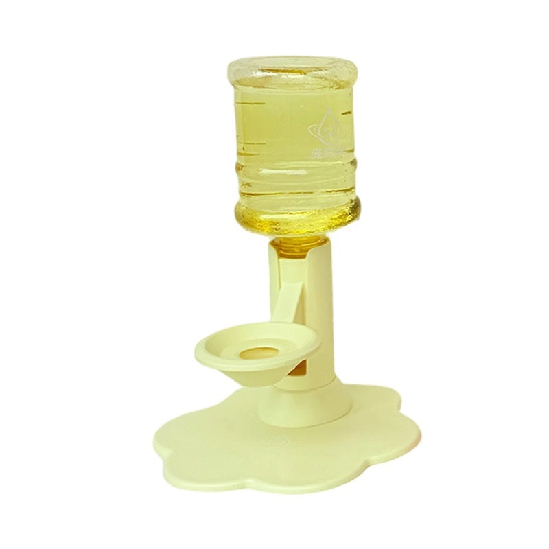 A pale yellow pet water fountain with a flower-shaped base, a central post, a small bowl, and a clear plastic water reservoir filled with yellow liquid, shown on a white background.
