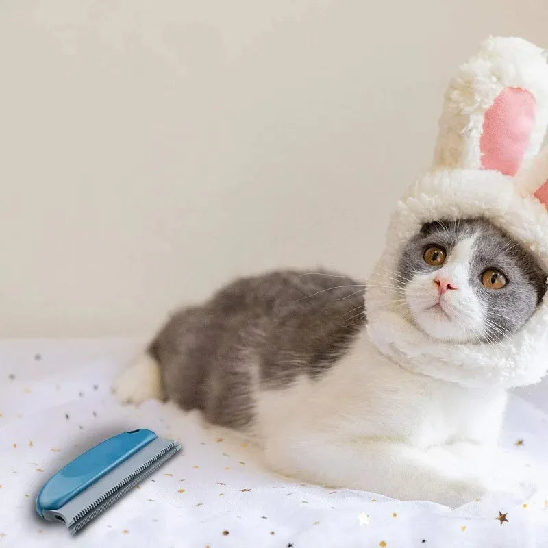 Cat wearing a bunny hat with a grooming brush on a white surface