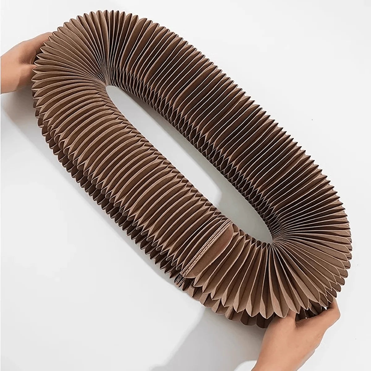 Cardboard tube sculpture held by hands on a white background