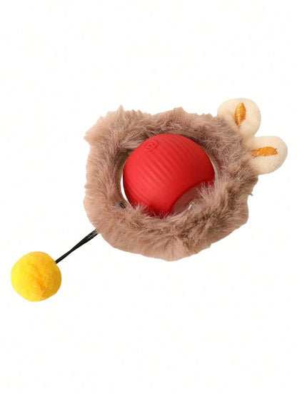 A plush toy or pet toy with a brown fuzzy nest-like body, a red oval center, cream-colored ear details, and a yellow pom-pom on a black string, shown on a plain white background.