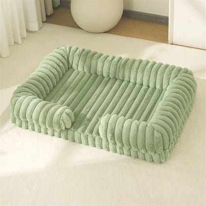 Green pet bed on a white surface with a neutral background