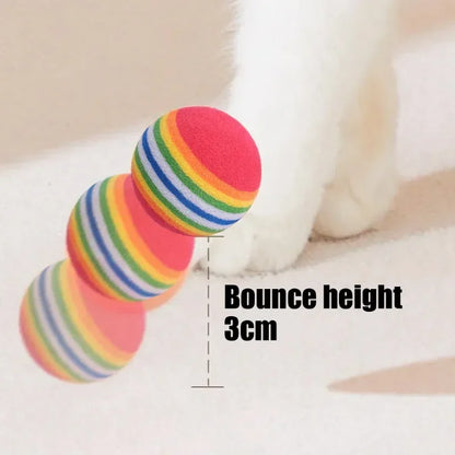 Colorful striped ball with a measurement indicating its bounce height on a soft surface.