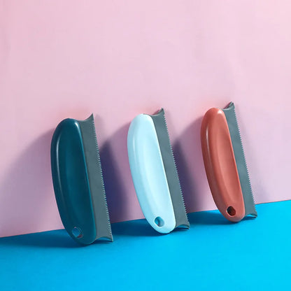 Three different colored scrub brushes on a pink and blue gradient background