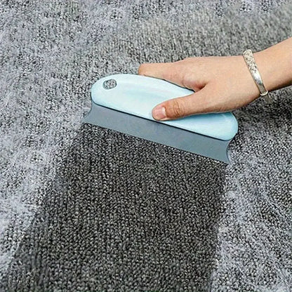 Person using a blue carpet cleaning tool on a gray carpet