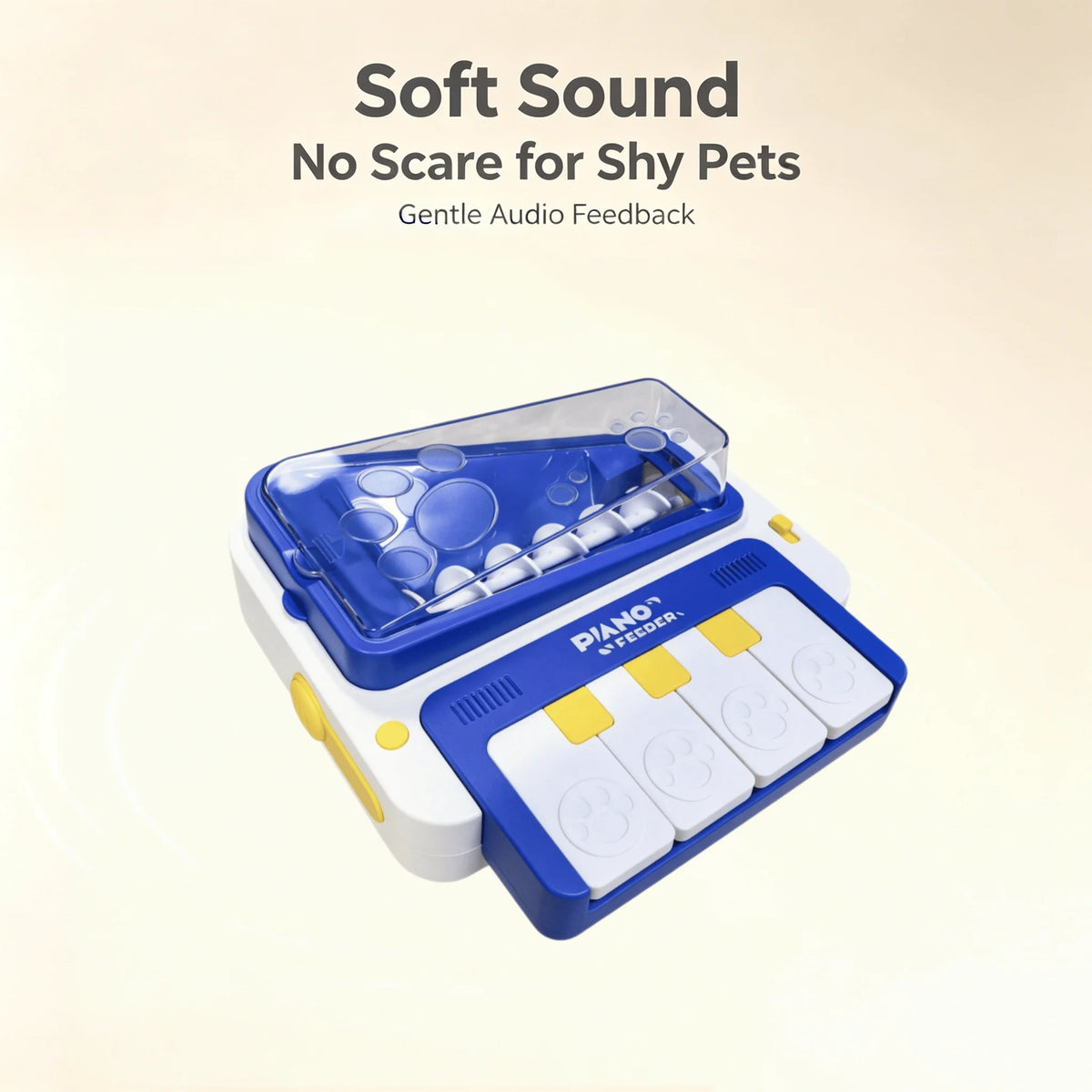 A blue and white pet training toy with yellow accents, featuring a small piano keyboard and a clear cover showing round training balls inside. Text above reads 'Soft Sound No Scare for Shy Pets Gentle Audio Feedback' on a light beige background.