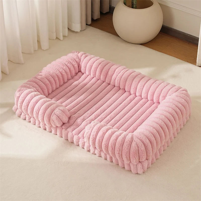 Pink pet bed on a light-colored floor with a curtain and plant in the background