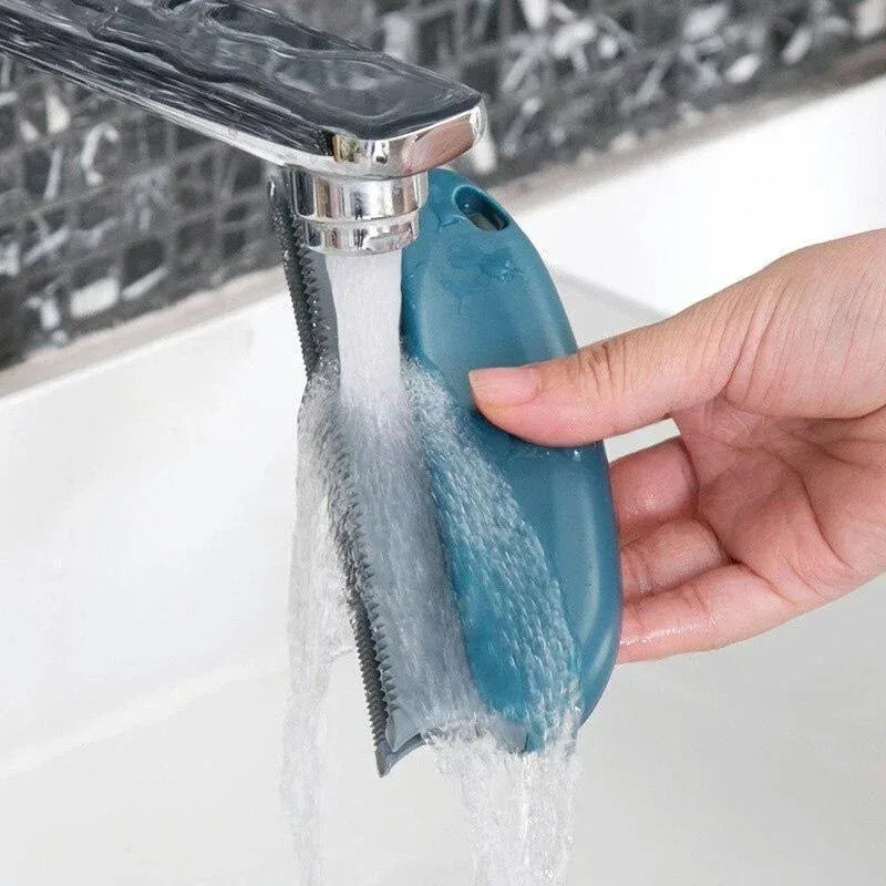 Hand holding a blue kitchen faucet filter with water flowing from it, set against a blurred kitchen background.