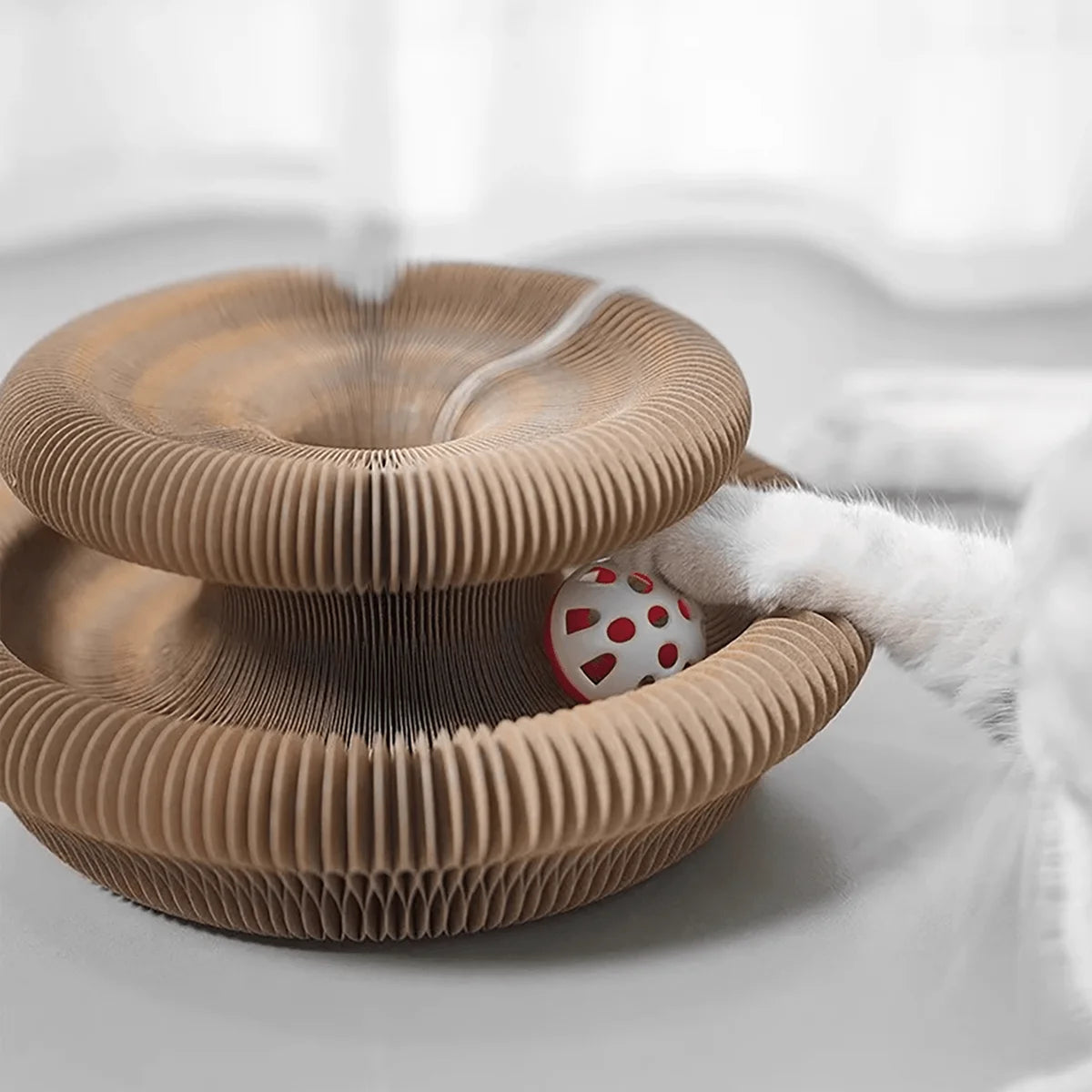 Cat toy with a ball inside on a white surface