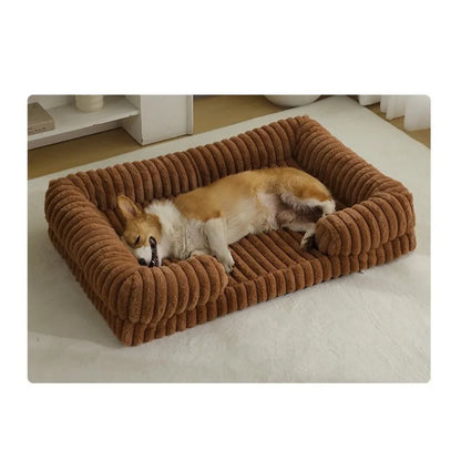 Two dogs lying on a brown plush pet bed in a room.