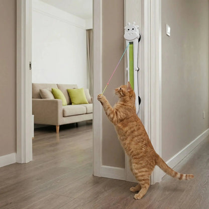 Cat playing with a toy attached to a door handle in a home setting.