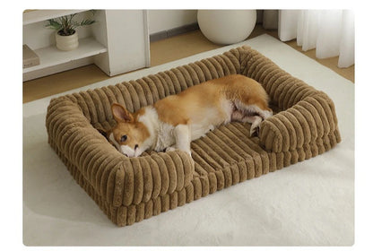 Dog lying on a brown plush pet bed in a room with a white rug and light-colored walls.