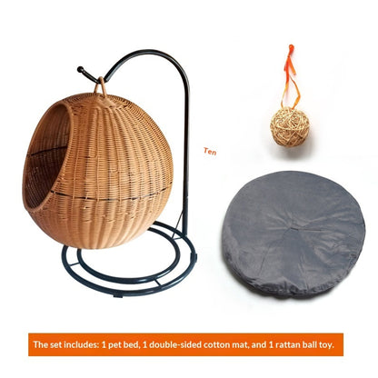 Wicker pet bed with stand, gray mat, and rattan ball toy on a white background