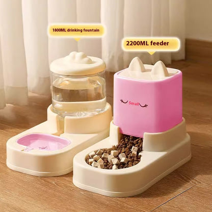 Pet feeding and drinking station with a pink feeder and beige fountain on a wooden floor.