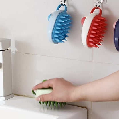 Person using a green scrubber to clean a kitchen surface with blue, red, and purple scrubbers hanging on hooks in the background.